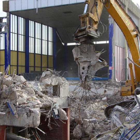 Metal cable being recovered by machine during building demolition