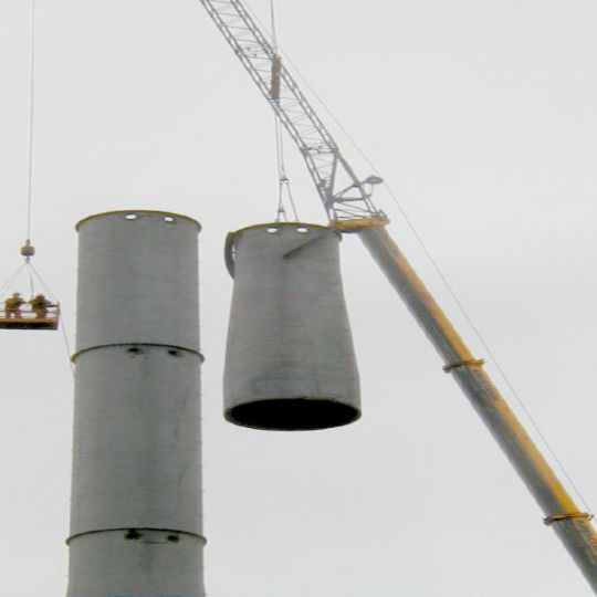Chimney being dismantled by crane